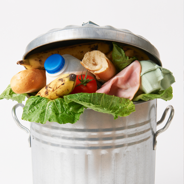 Mülleimer – überfüllte – beinhaltet Lebensmittel wie Bananen, Brot, Schinken und Salat in Küche.